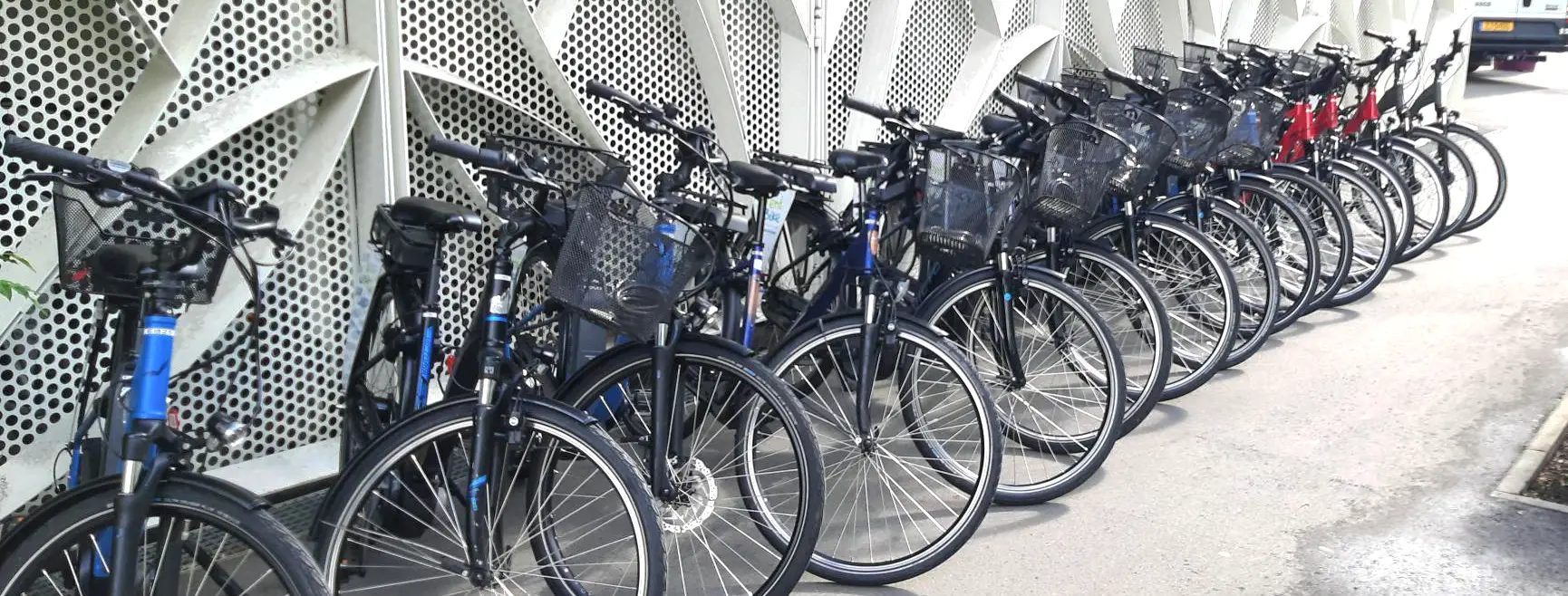 Reihe von RentaBike Miselerland Fahrrädern an einer Verleihstation